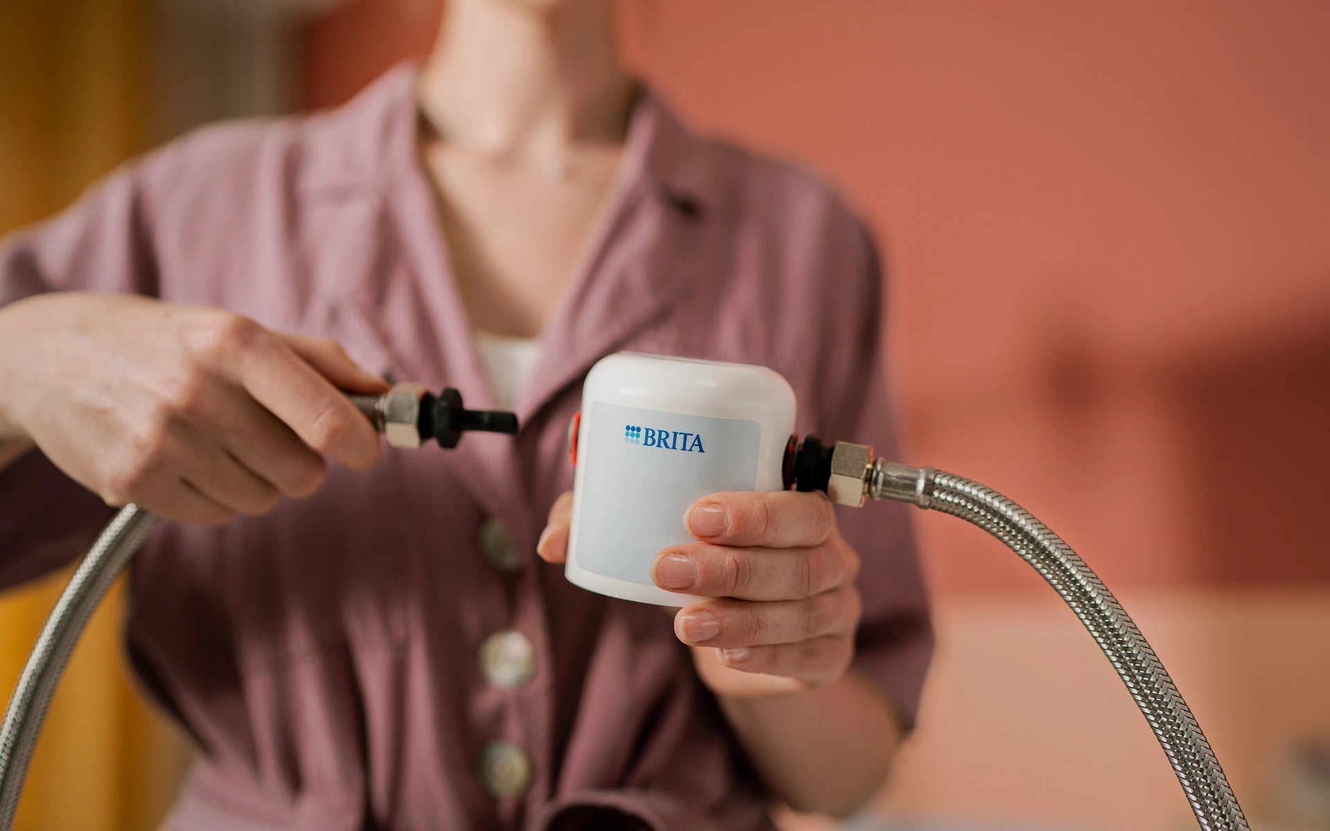 BRITA spare part connector being attached to water hoses during installation