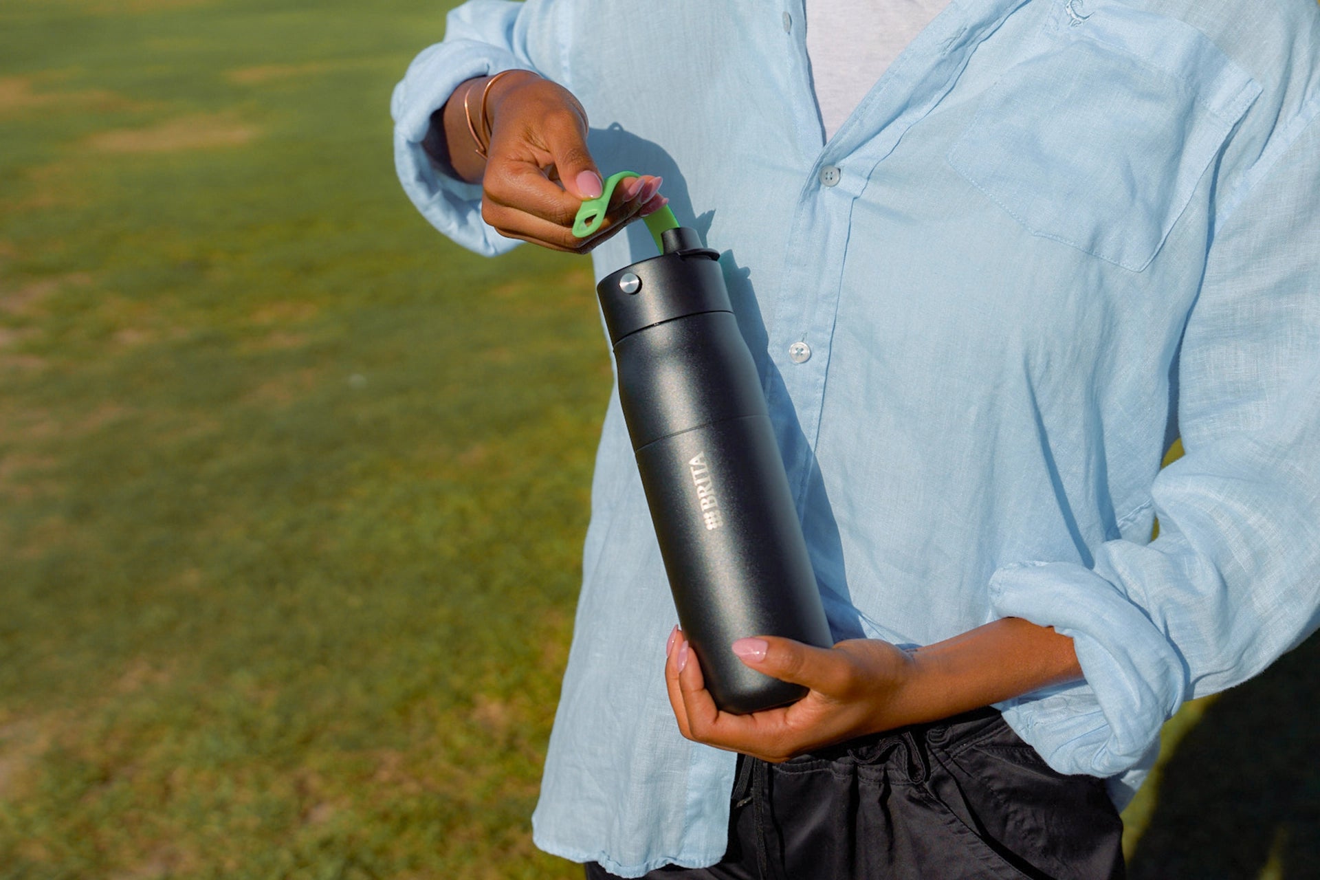 Black BRITA LARQ bottle with green handle accessory attached to the lid
