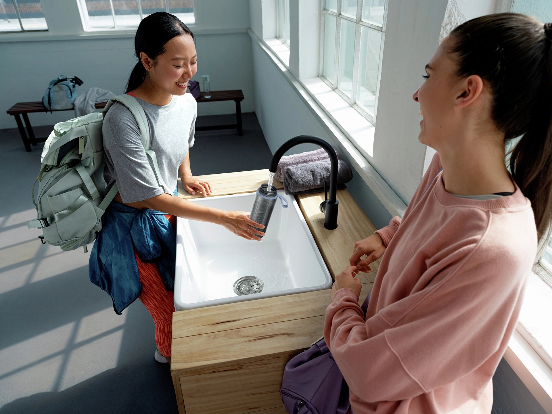 Woman filling BRITA water filter bottle Model Active in gym