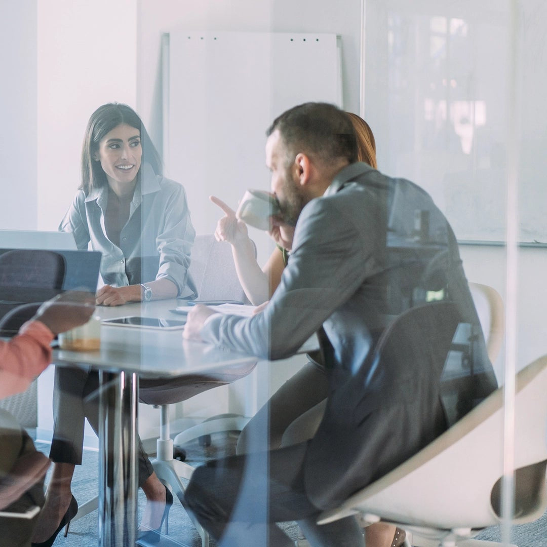 Group of people in a modern office setting during a meeting.