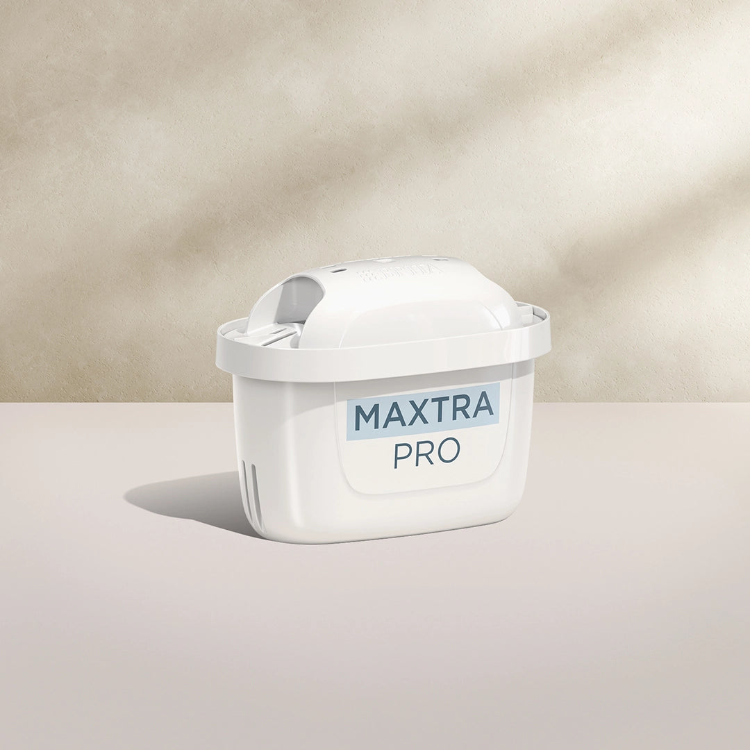 A BRITA MAXTRA PRO PURE PERFORMANCE water filter cartridge on a beige background
