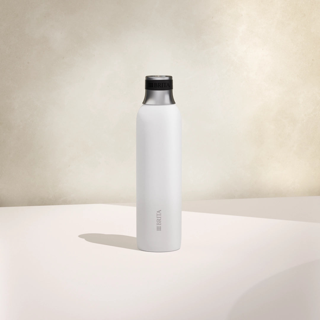 One small white BRITA sodaTRIO stainless steel bottle on a beige background