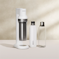BRITA sodaTRIO Sparkling Water Maker in white with two bottles on a beige background.